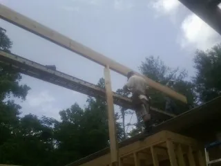 Carpenter setting a ridge beam over a new addition frame — Ice Dam Removal by Roofing Brothers in Hitterdal