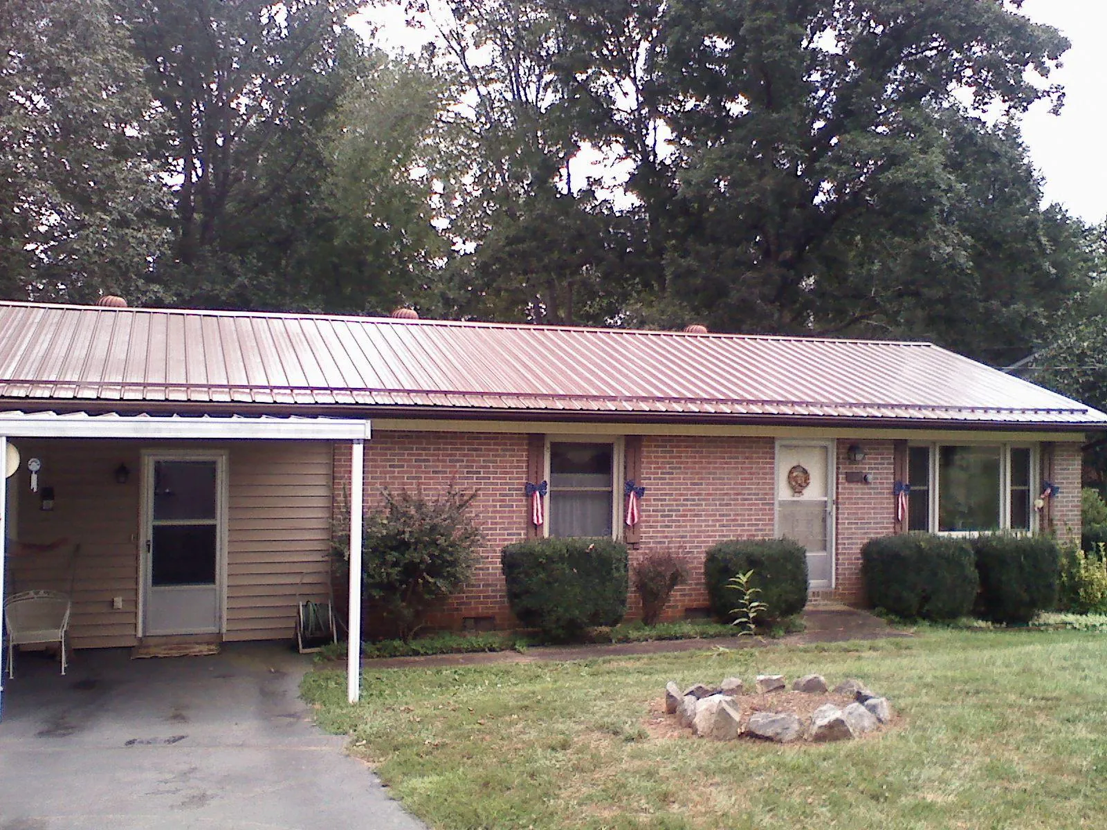 Bronze metal roof and carport on a brick ranch home — Roof Repair work by our crew in Hitterdal